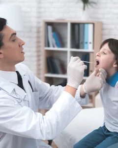 רופא אף אוזן גרון באר שבע בודק גרון של ילד לפני ניתוח שקדים